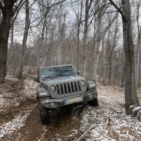Winter Jeep ride on a sloping forest path.